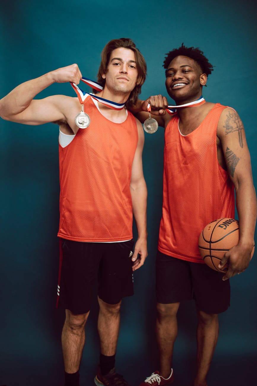 basketball players posing together while holding their medals