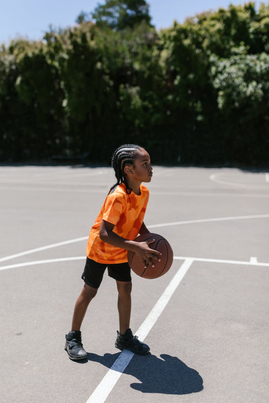 boy in orange shirt playing ball