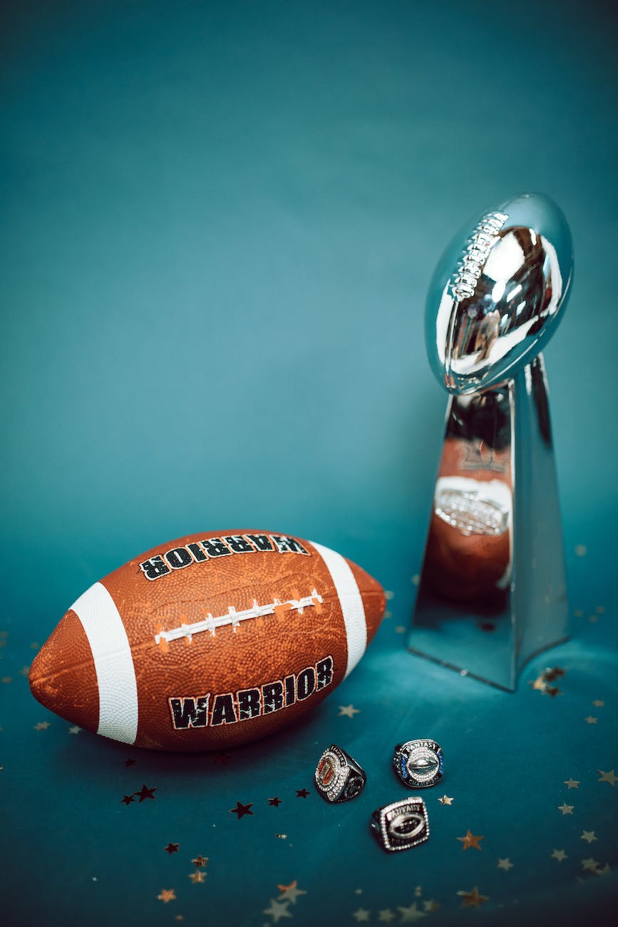 a pigskin football and a vince lombardi trophy