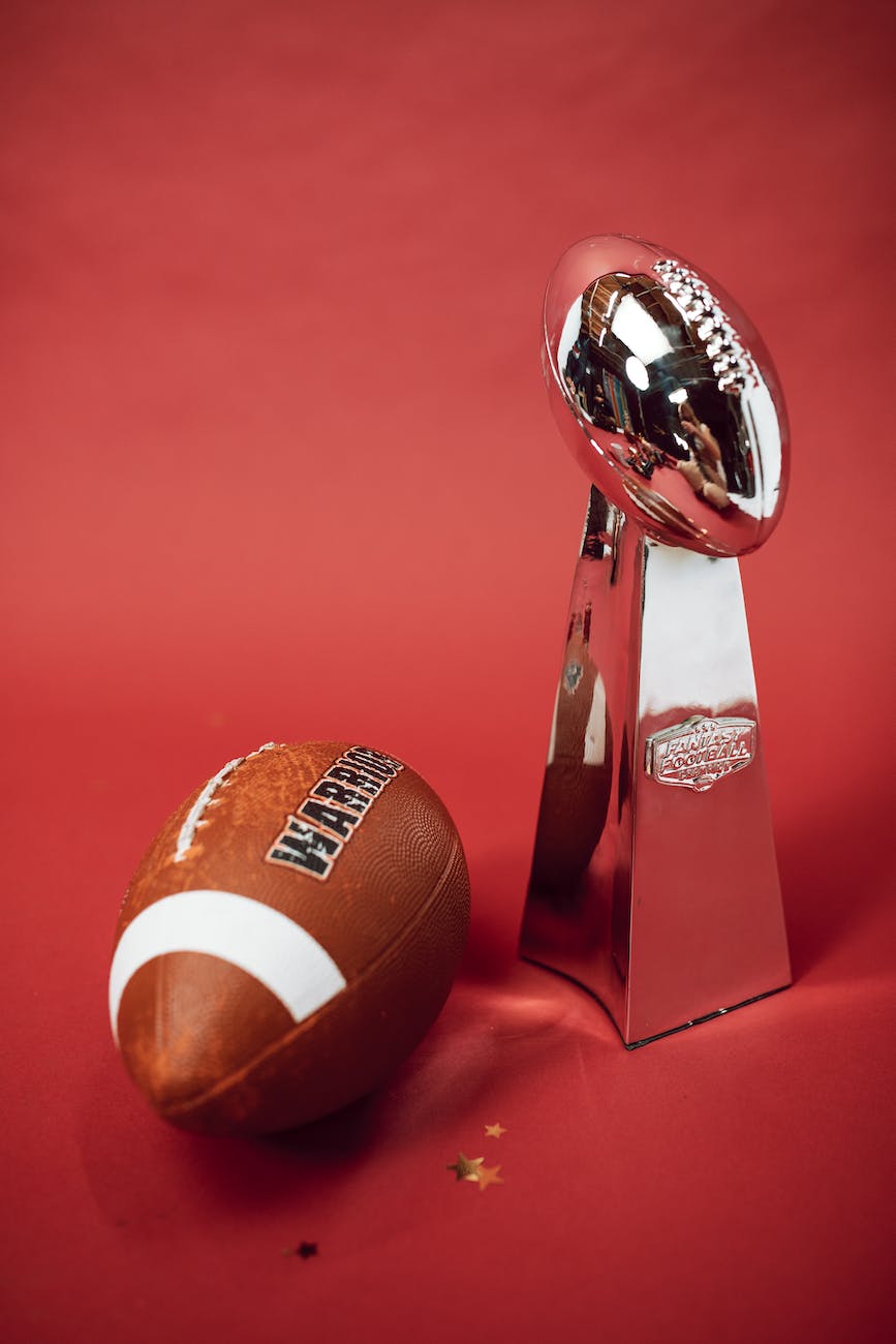 a pigskin football and a silver trophy
